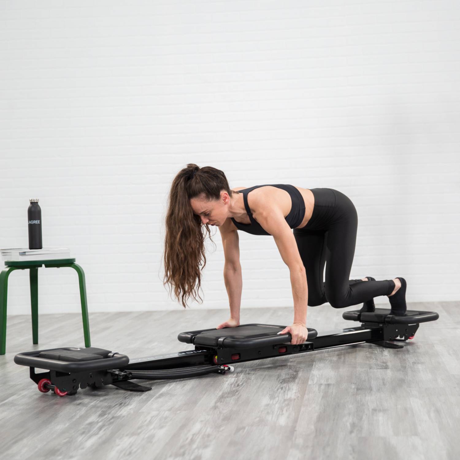Femme faisant un exercice de fitness Lagree sur microformer dans un studio